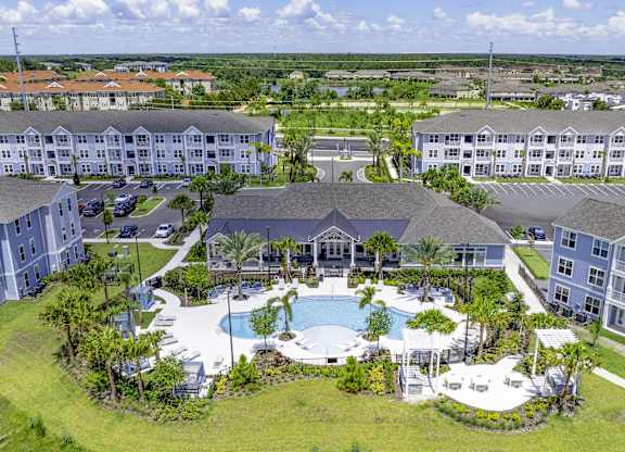 A large resort with a pool and palm trees.