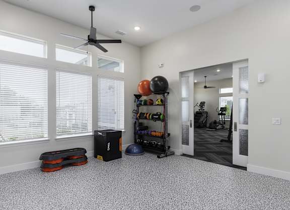 a living room with a large window and a ceiling fan