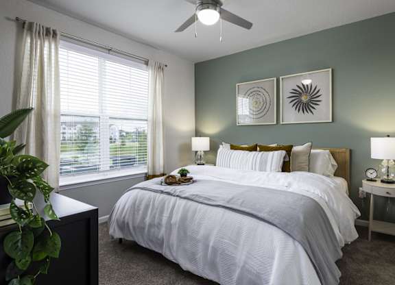a bedroom with a large bed and a ceiling fan
