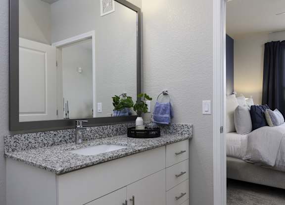 a bathroom with granite counter top and a large mirror