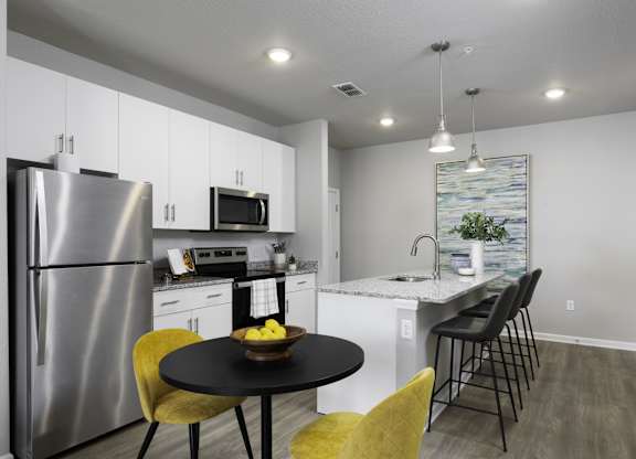 a kitchen with stainless steel appliances and a table with chairs