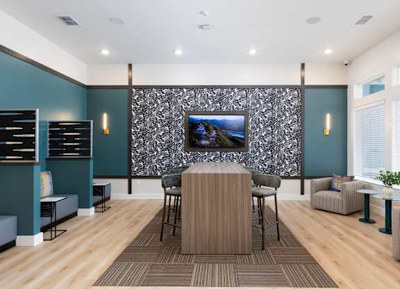 a conference room with a table and chairs and a tv on the wall