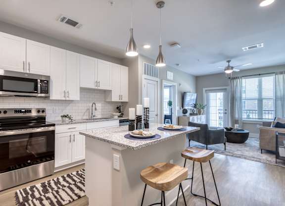 A modern kitchen with a center island and stools.