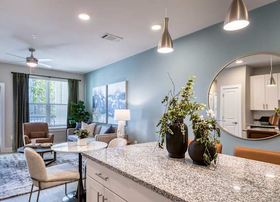 A kitchen with a table and chairs and a fan.