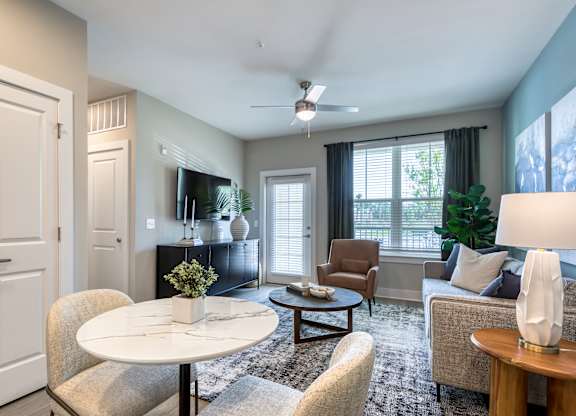 A living room with a white table and chairs.