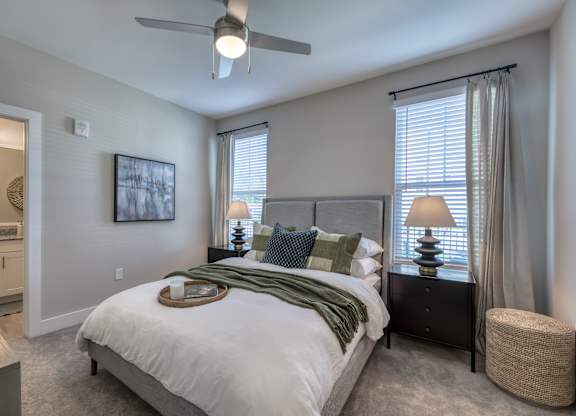 A bedroom with a bed, nightstand, and a ceiling fan.