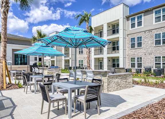 A patio with a table and chairs under a blue umbrella.