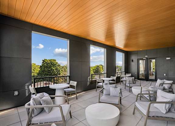 A patio with white furniture and a wooden ceiling.
