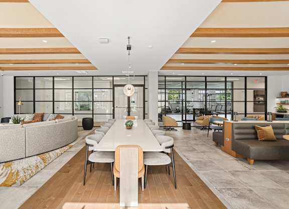 A modern living room with a long table and chairs.