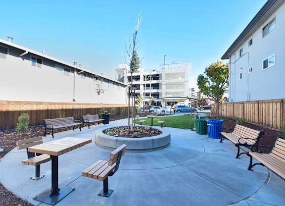 an outdoor seating area with benches and a fire pit