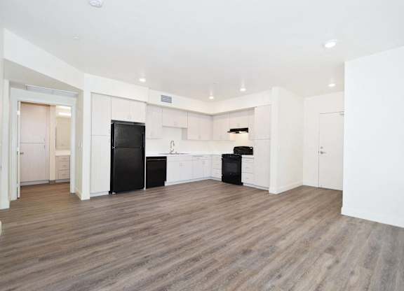 an empty room with white walls and wood floors