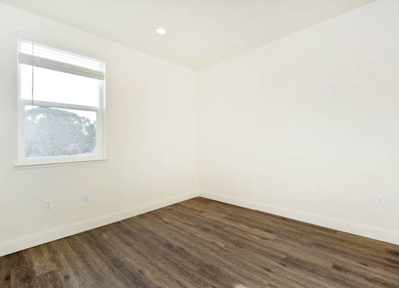 an empty room with white walls and a window
