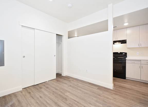 a renovated living room with white walls and wood flooring