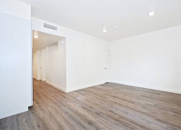 A room with wooden flooring and white walls.