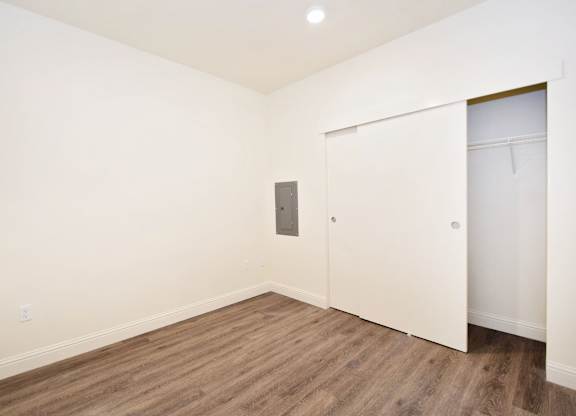 an empty room with white walls and wooden floors