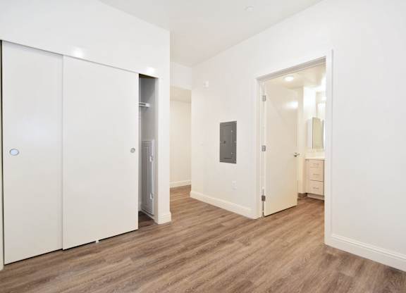 A room with a white door and a white cabinet with a blue circle on it.