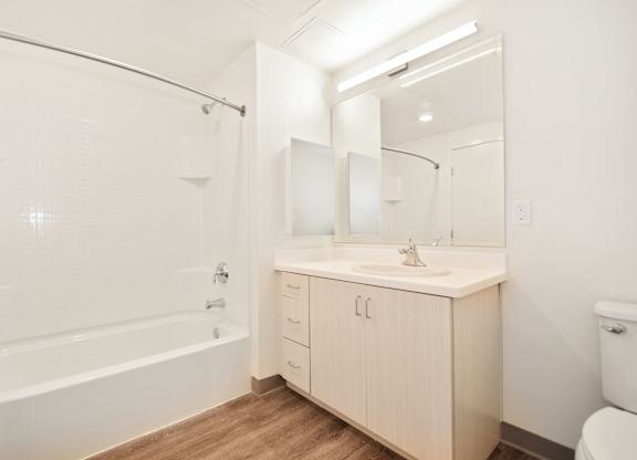 a bathroom with a shower sink and toilet and a mirror