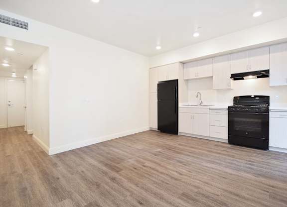 A kitchen with black appliances and white cabinets.