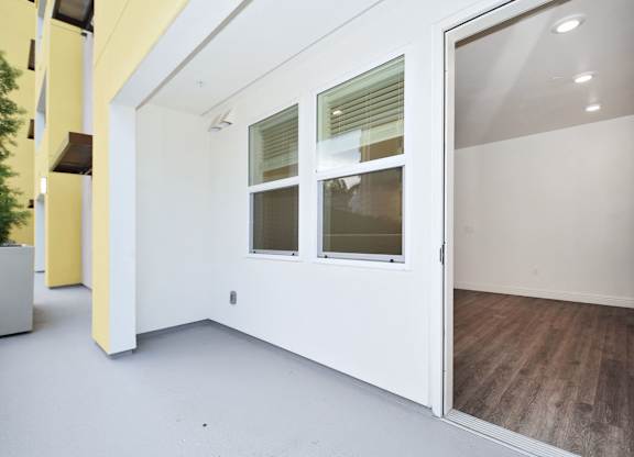an empty room with white walls and a glass door