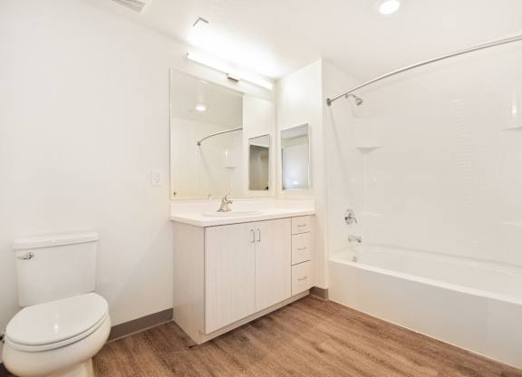 A white bathroom with a toilet, sink, and bathtub.