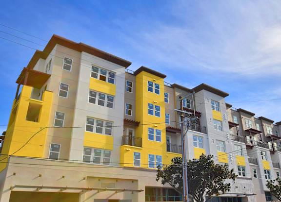 A multi-story building with yellow and white balconies.