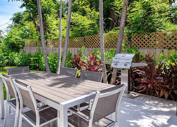 A wooden table with chairs in a garden.