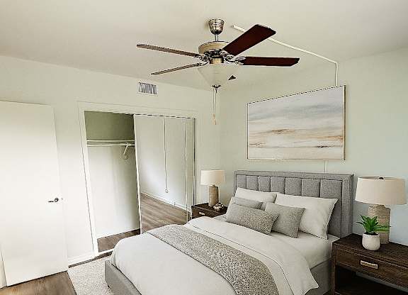 A bedroom with a bed, nightstand, and a ceiling fan.