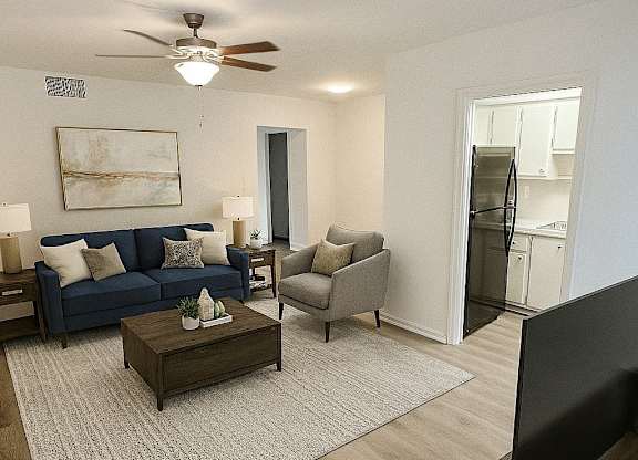 A living room with a blue couch, a coffee table, and a television.