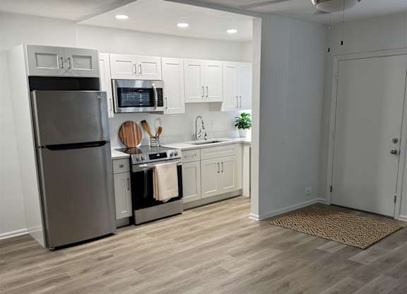 A kitchen with a refrigerator, stove, and oven.