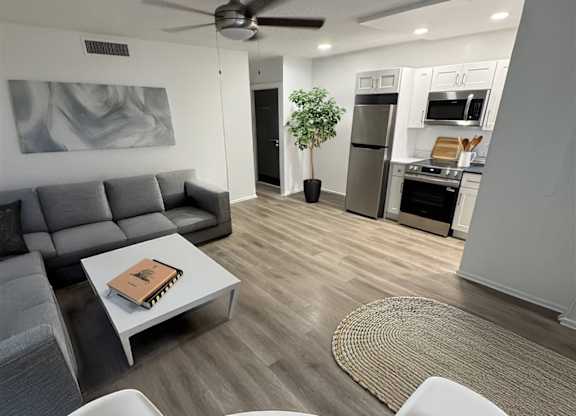 A modern living room with a grey couch and a white coffee table.