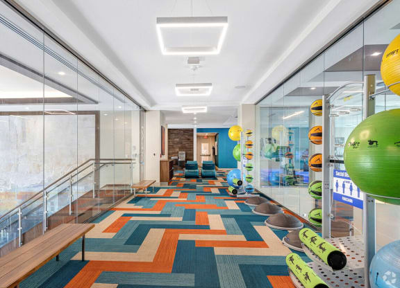 a long hallway with glass walls and a colorful carpet on the floor