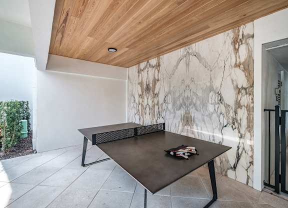 a ping pong table in the pool area of the home