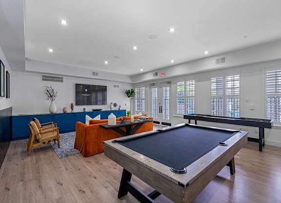 a game room with a pool table and a television