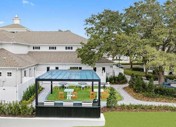 an aerial view of the backyard of a mansion with a garden and a greenhouse
