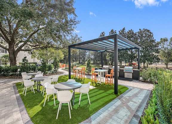 a patio with tables and chairs under a canopy