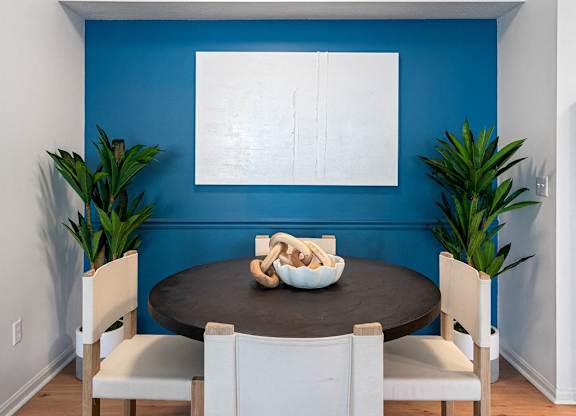 a dining room with a blue wall and a table and chairs