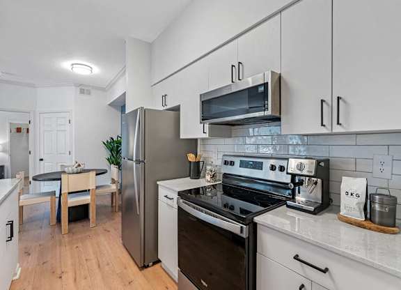 a kitchen with stainless steel appliances and white cabinets
