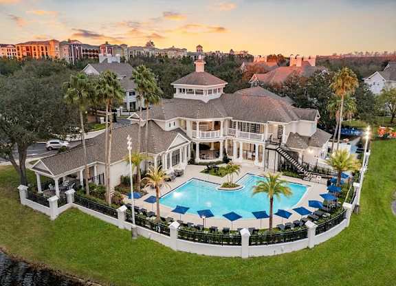 an aerial view of a mansion with a large swimming pool