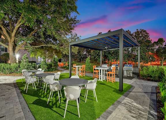 a patio with tables and chairs and a pergola