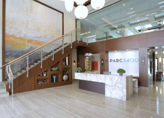 a large lobby with a staircase and a reception desk