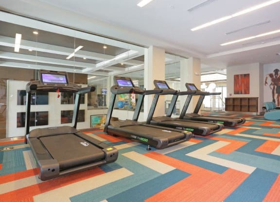 a gym with treadmills on the floor