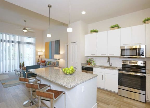 a kitchen and living room with a marble counter top