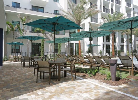 a patio with tables and chairs and umbrellas
