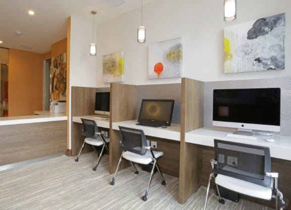 a conference room with desks and chairs and paintings on the wall
