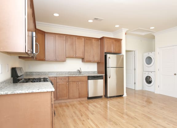a kitchen with brown cabinets and a white washer and dryer at Greenway Village Apartments, Metuchen, NJ