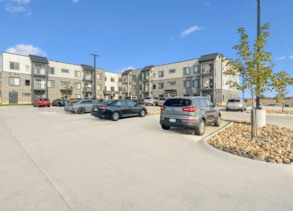 A parking lot with cars and apartment buildings in the background.