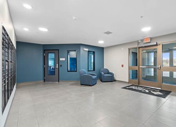 A hallway with a blue wall and a glass door.