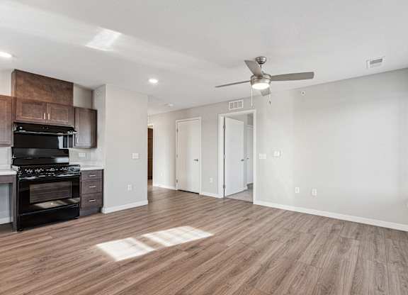 A spacious room with a ceiling fan and lighting fixtures.