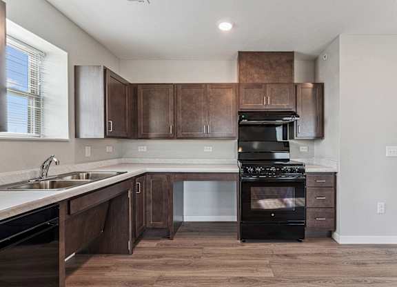 A modern kitchen with dark wood cabinets and a black stove top oven.