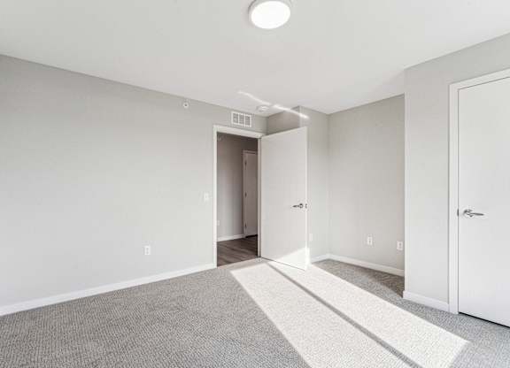 A room with a carpeted floor and a white door.